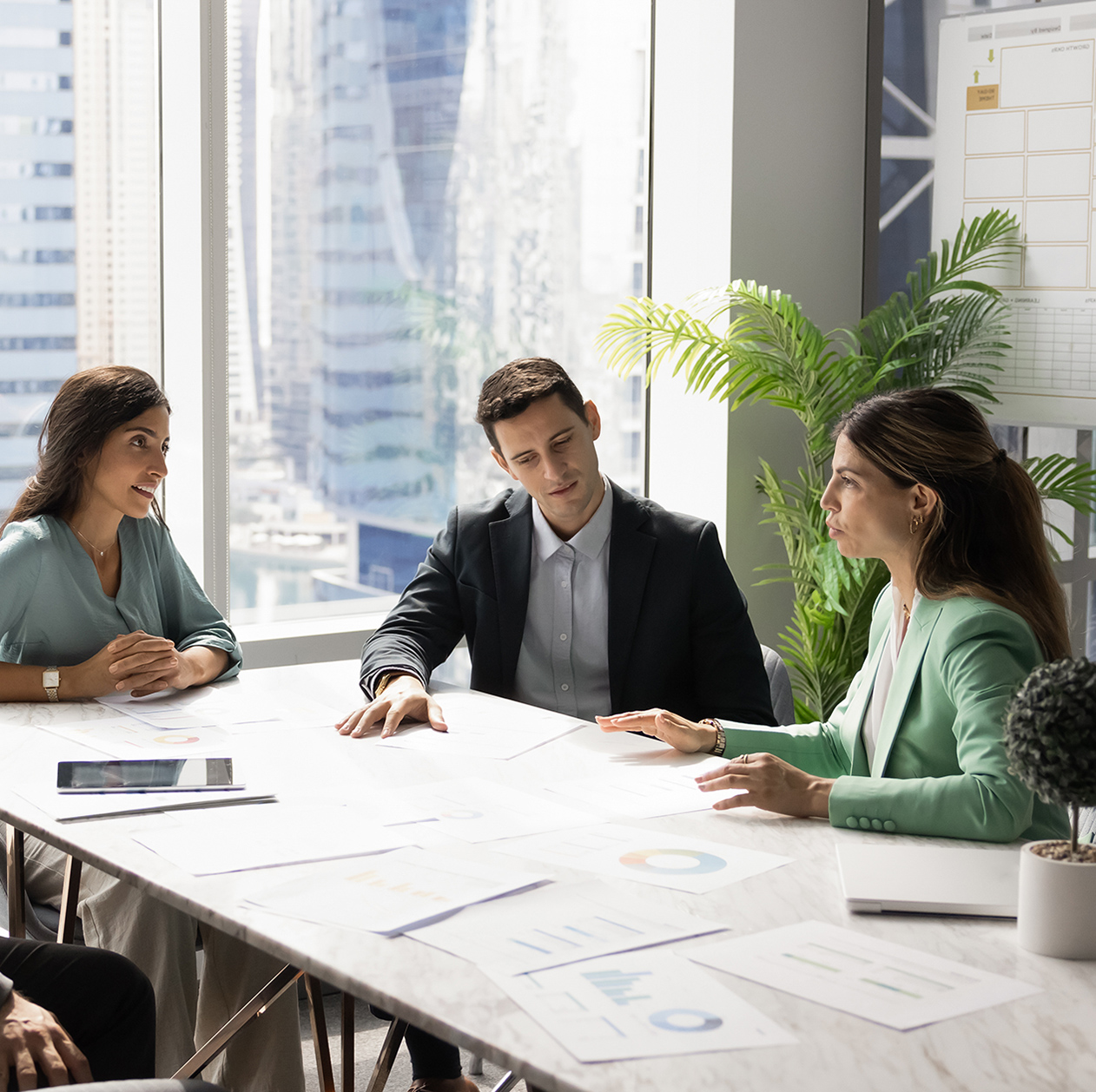 Business team talking at table in meeting room, discussing job tasks, teamwork in modern office workspace, sharing ideas for brainstorming. Stakeholders planning cooperation, marketing strategy